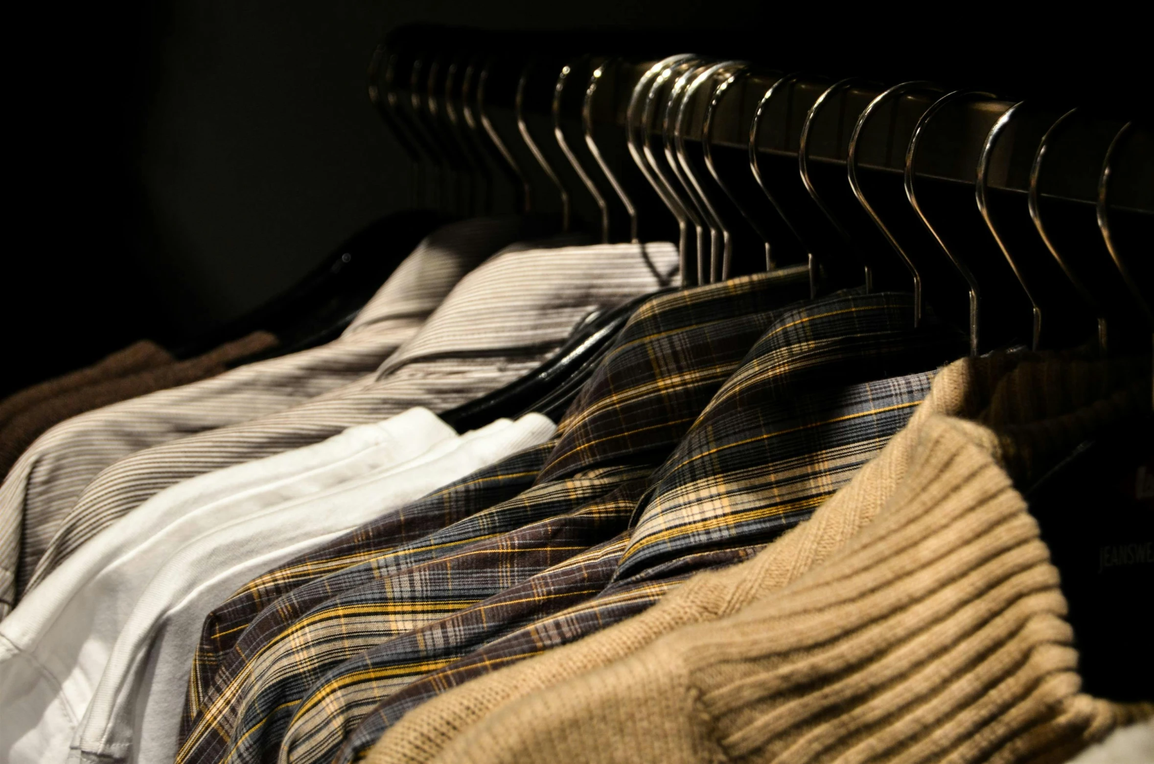 a row of men's shirts hanging on a rack, by Carey Morris, trending on unsplash, renaissance, muted brown yellow and blacks, tartan garment, thumbnail, technologies
