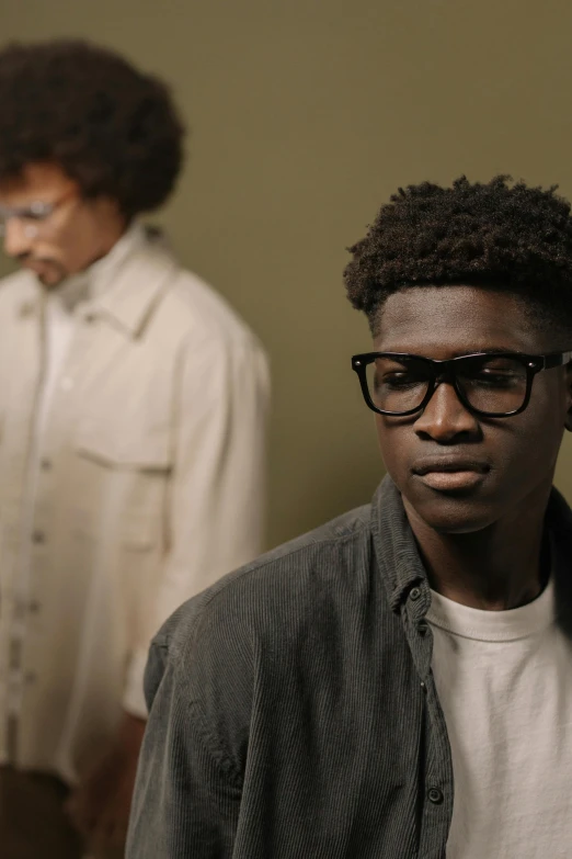 a couple of men standing next to each other, by Everett Warner, trending on unsplash, renaissance, black glasses, male teenager, ( ( theatrical ) ), muted brown