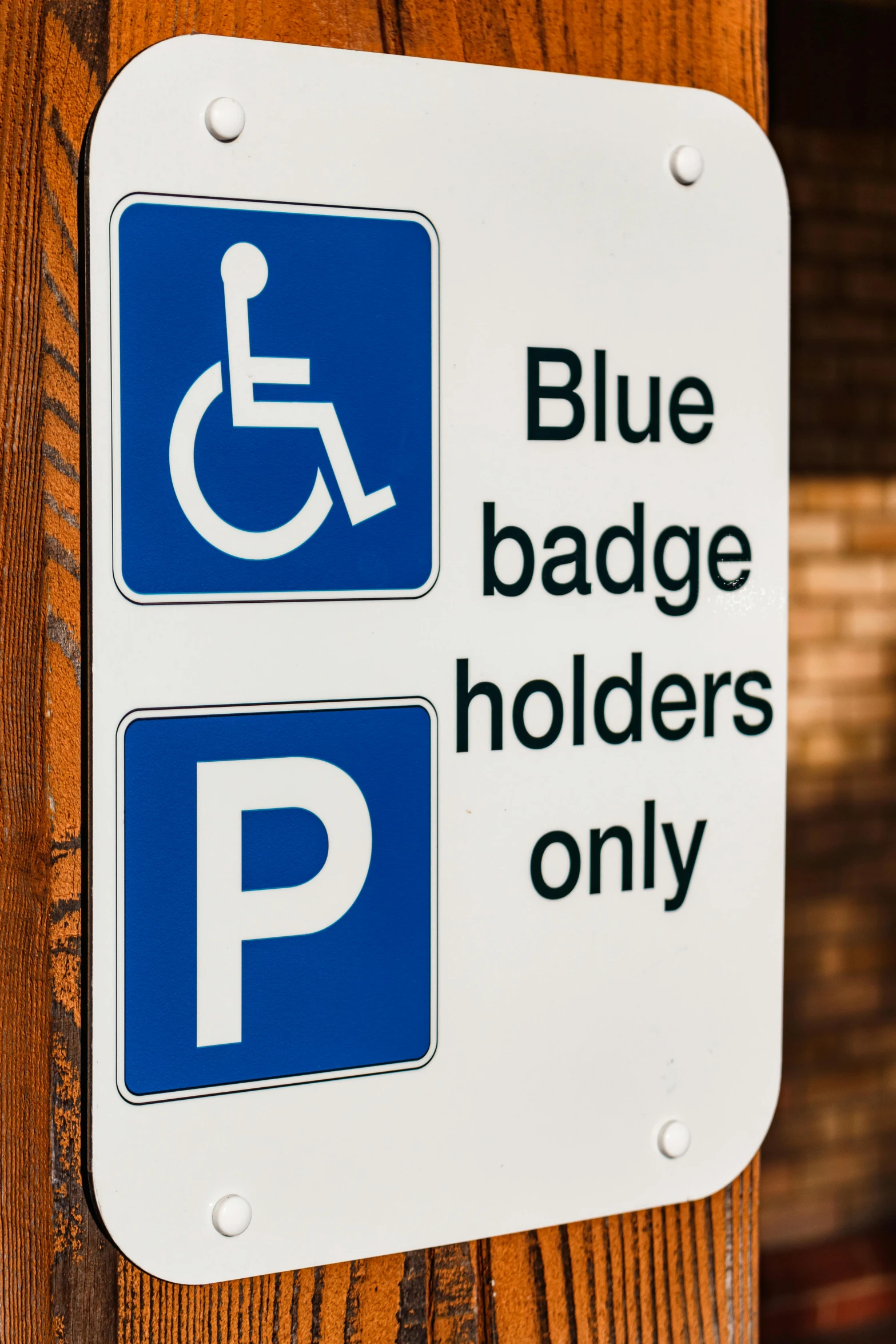 a blue and white sign that says blue badge holders only, paul barson, symbols, colour corrected, 2022 photograph