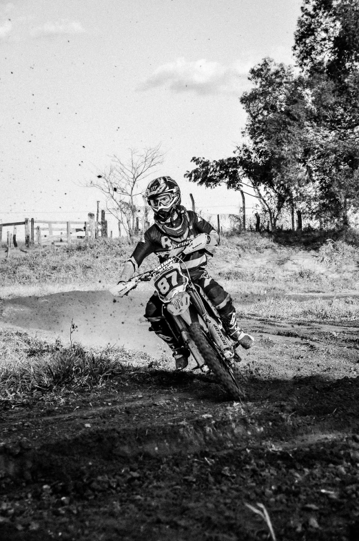 a man riding on the back of a dirt bike, a black and white photo, uploaded, sport, graeme base, at home