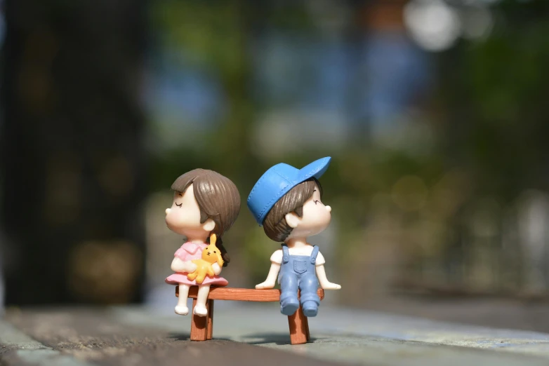 a couple of figurines sitting on top of a bench, pexels contest winner, stranger things character, childrens toy, al fresco, cutest