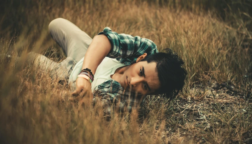 a man laying on the ground in a field, pexels contest winner, fantastic realism, non binary model, avatar image, rustic, with a hurt expression