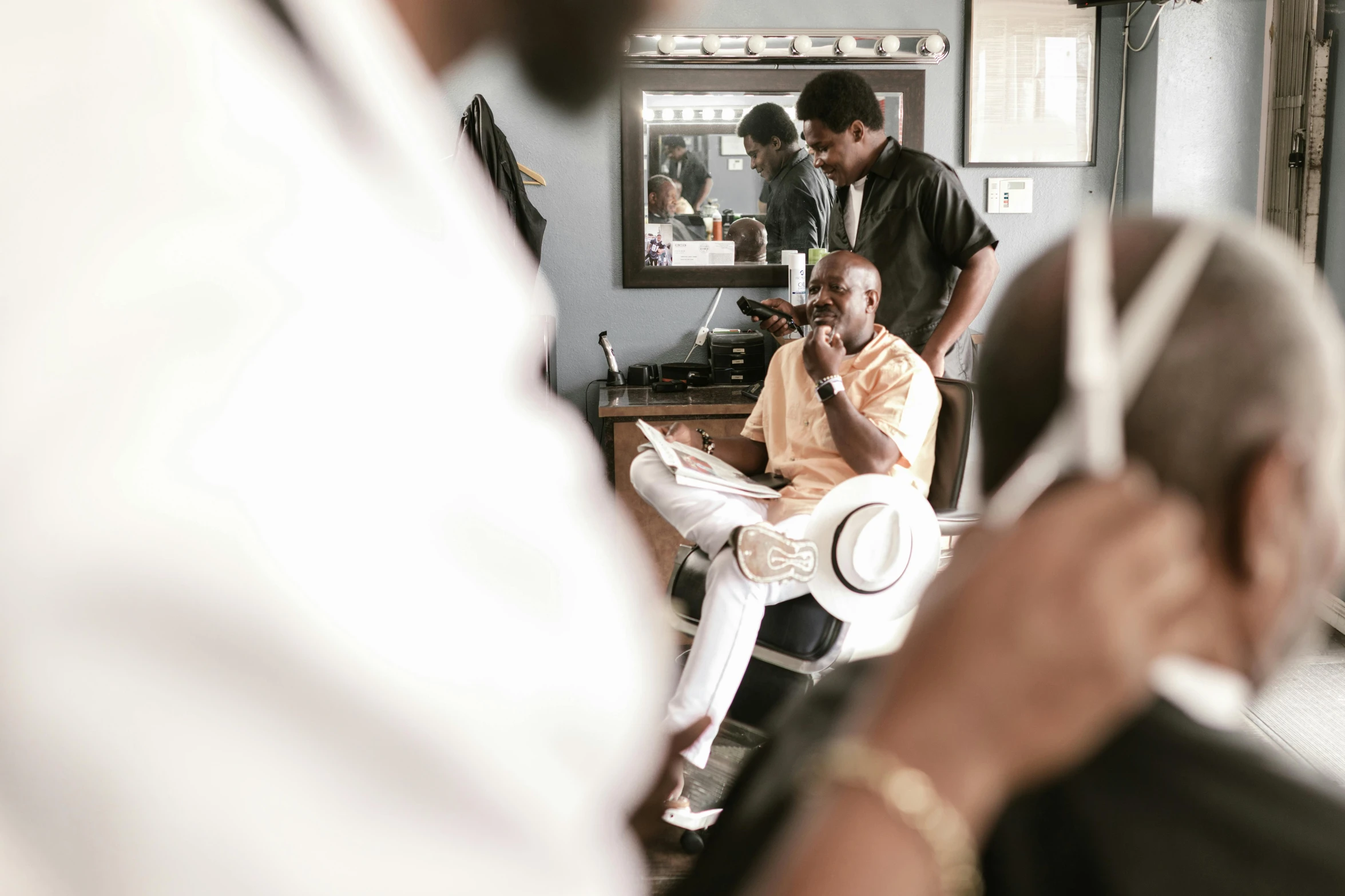 a man getting his hair cut at a barber shop, by Dan Frazier, pexels contest winner, lance reddick, man sitting facing away, thumbnail, makeup