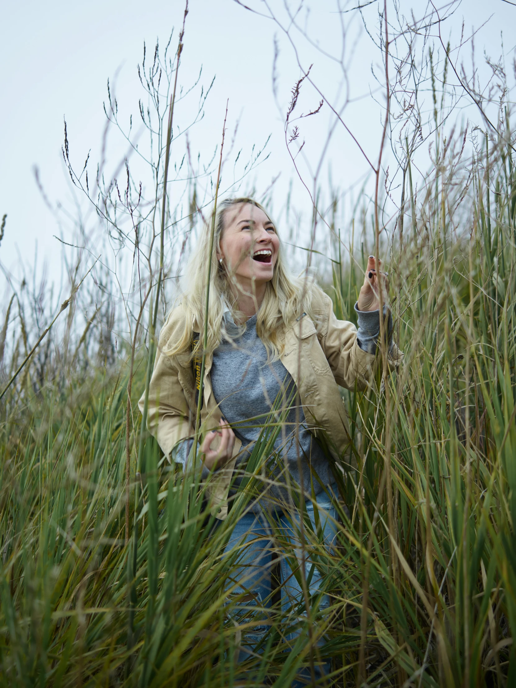 a woman laughing in a field of tall grass, happening, nina tryggvadottir, on the coast, roots and hay coat, olya bossak