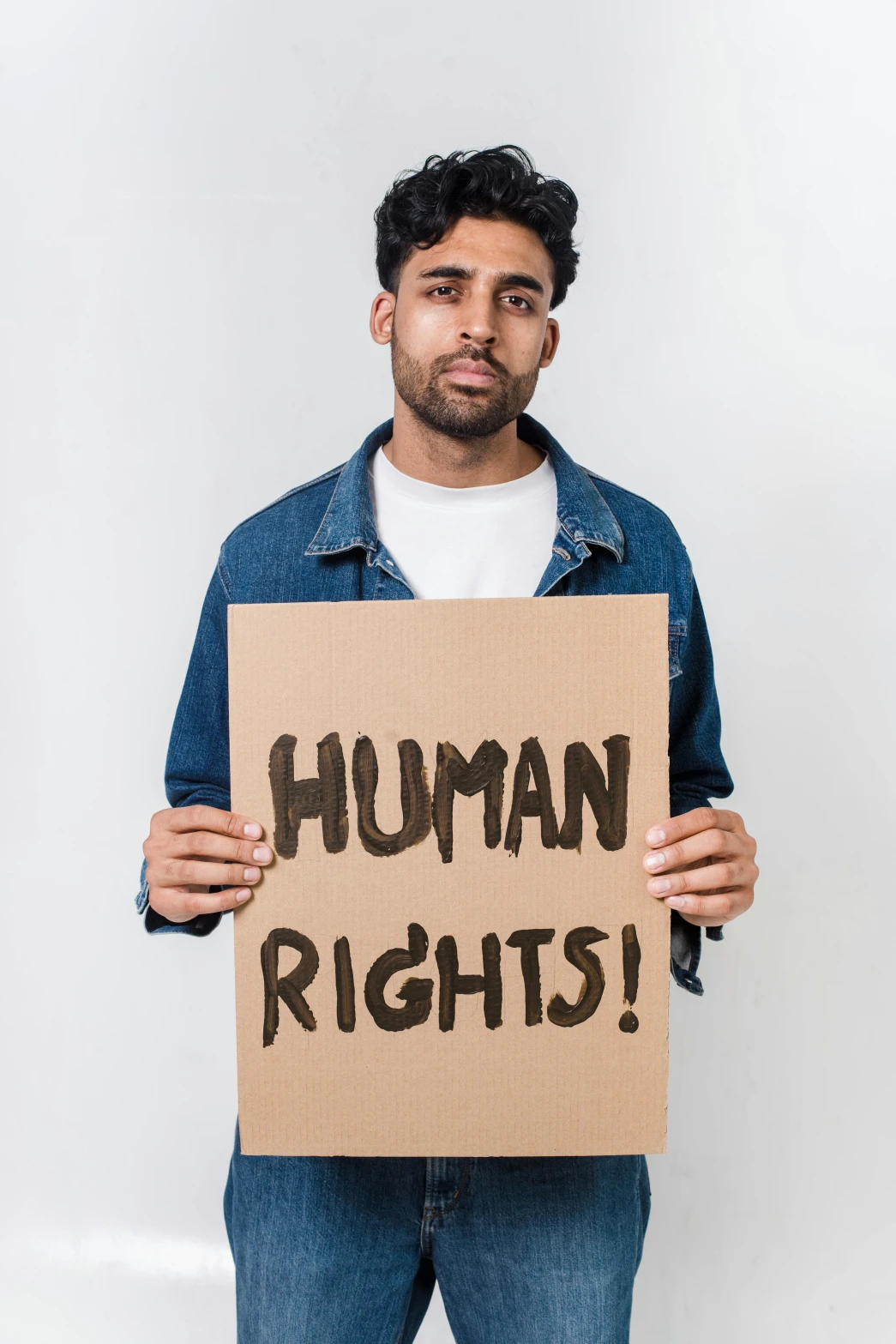 a man holding a sign that says human rights, an album cover, shutterstock, renaissance, indian, young adult male, alex flores, why