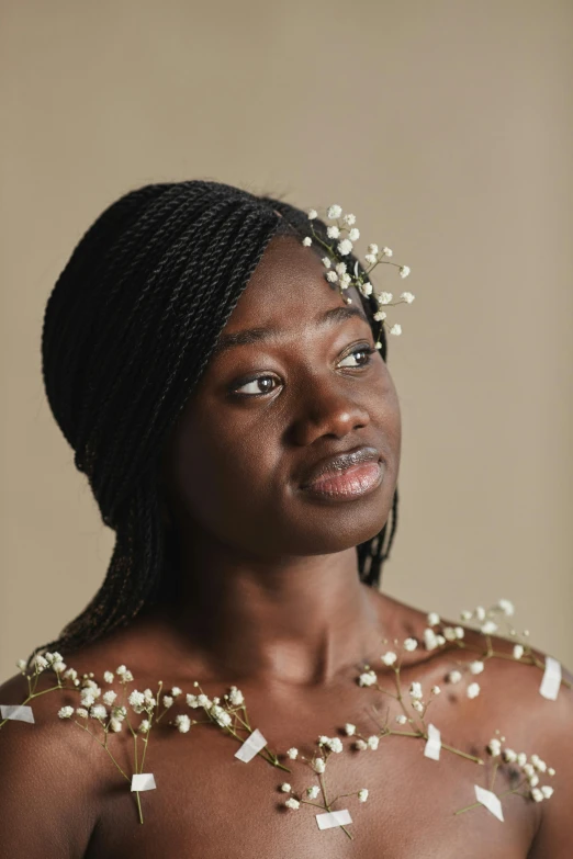 a woman with a flower in her hair, inspired by David Bailly, trending on pexels, adut akech, wearing a dress made of beads, studio portrait, black teenage girl