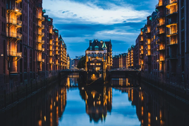 a river running through a city next to tall buildings, by Micha Klein, pexels contest winner, art nouveau, tall windows lit up, lower saxony, docks, 🚿🗝📝