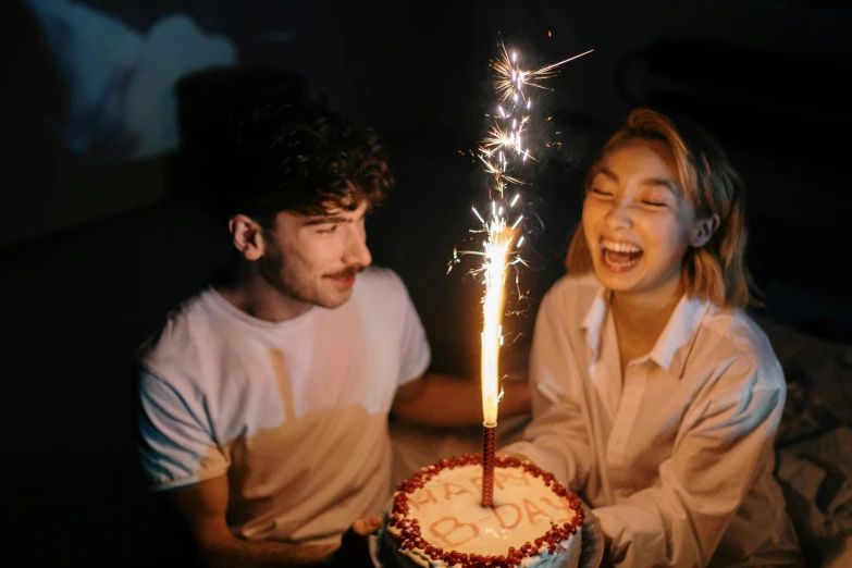 a man and a woman sitting in front of a cake with sparklers, pexels, pals have a birthday party, avatar image, cinematic movie image