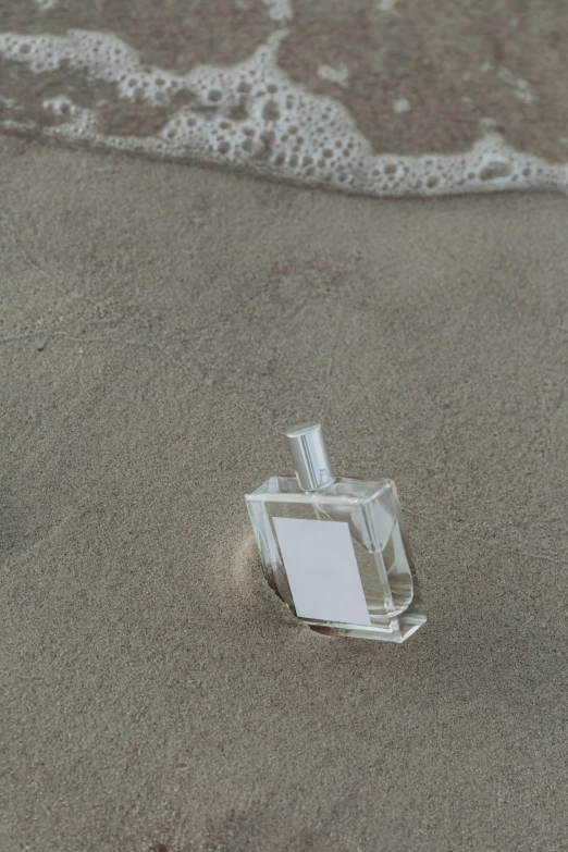 a bottle of perfume sitting on top of a sandy beach, inspired by Vija Celmins, modeled, rectangle, micro detail, detailed product image