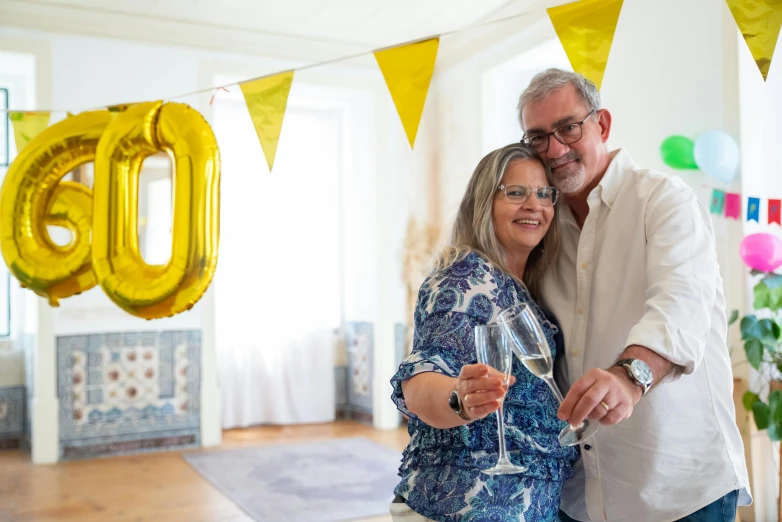 a man and a woman standing next to each other, by Pamela Drew, pexels, happening, party balloons, 4 0 years, silver and yellow color scheme, at home