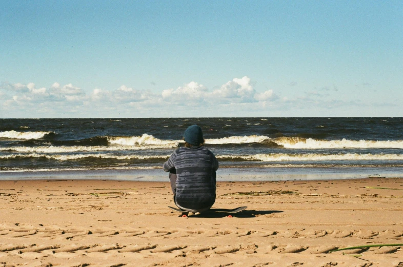 a person sitting on top of a sandy beach, pexels contest winner, minn, man sitting facing away, chillwave, cardboard