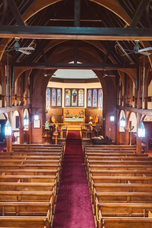 a church with pews and stained glass windows, wide aerial shot, bright lit interiors, wooden interior, manly