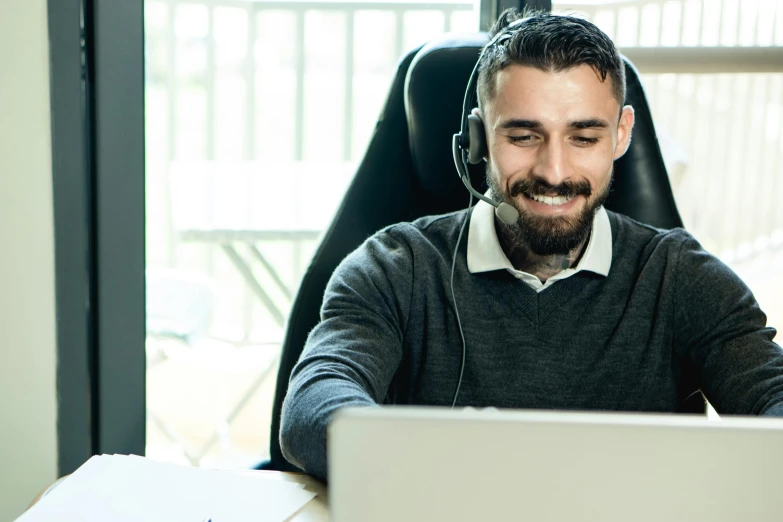 a man sitting in front of a laptop wearing a headset, inspired by Edi Rama, trending on pexels, hurufiyya, smug smile, lachlan bailey, thumbnail, enhanced quality