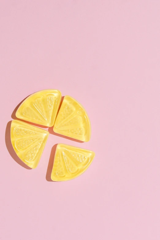 a slice of lemon on a pink background, by Justin Sweet, trending on pexels, made of lollypops, edible crypto, 6 pack, curved