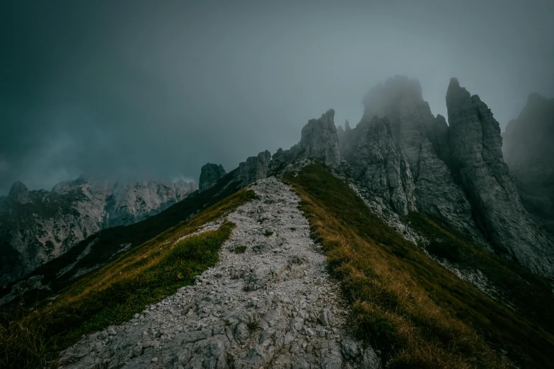 a trail going up the side of a mountain, by Sebastian Spreng, pexels contest winner, romanticism, tall stone spires, ominous atmosphere, atmospheric establishing shot, italy