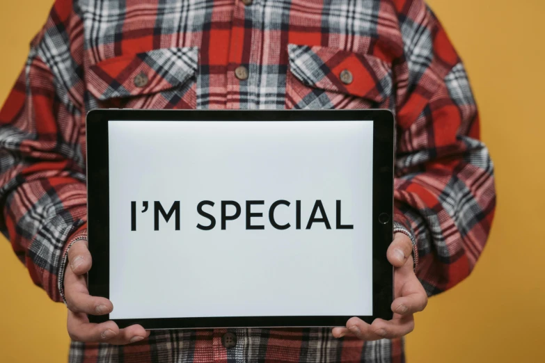 a man holding a sign that says i'm special, pexels, ipad pro, digital banner, brown, single person