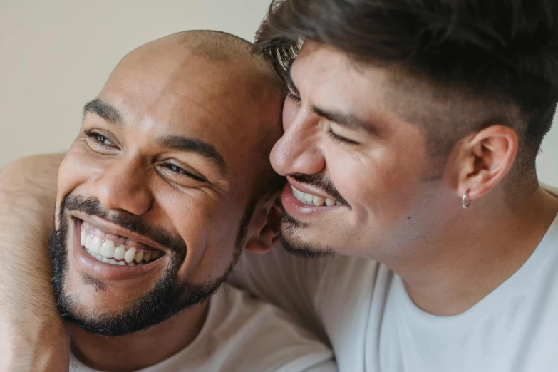 a couple of men sitting next to each other, smiling mouth, profile image, queer, background image