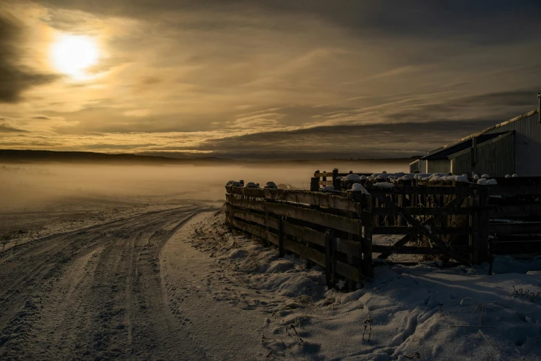 a barn sitting on top of a snow covered field, by Harald Giersing, pexels contest winner, foggy sunset, inuk, vehicle, winter lake setting