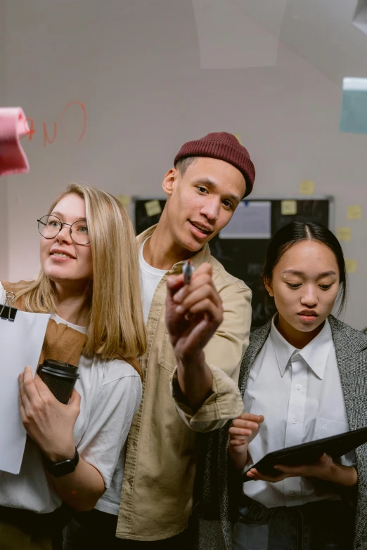 a group of people standing around each other, trending on pexels, arbeitsrat für kunst, holding a clipboard, studious, pointing, lit up