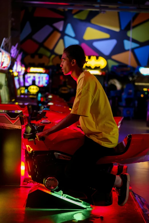 a man sitting on top of a red scooter, arcade game, neon blue and yellow lights, teen boy, over the shoulder shot