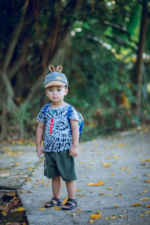 a little boy that is standing on a sidewalk, inspired by Eiichiro Oda, pexels, jungle camo, rabbit ears, avatar image, lookbook