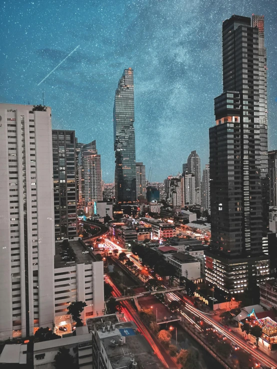 a view of a city at night from a high rise building, an album cover, pexels contest winner, ☁🌪🌙👩🏾, tall buildings on the sides, galaxy, bangkok