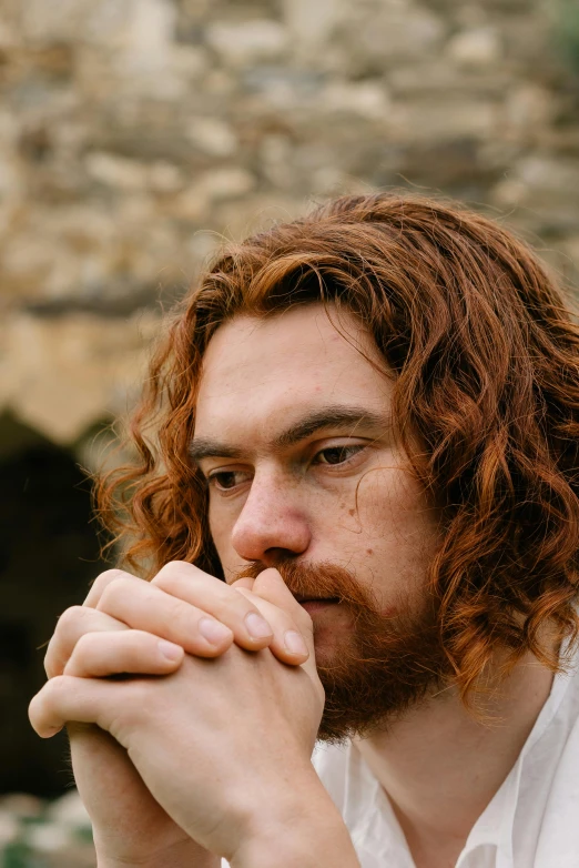 a man with red hair wearing a white shirt, inspired by Andrew Robertson, unsplash, renaissance, looking melancholy, hozier, hands on face, holy man looking at ground