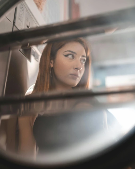 a woman looking at herself in a mirror, a polaroid photo, inspired by Elsa Bleda, trending on unsplash, fantastic realism, the woman is behind bars, man looks out of a train window, a redheaded young woman, trans rights