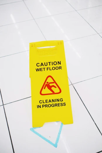a caution wet floor sign on a tiled floor, pexels, thumbnail, 8 k cleaning future, english, high angle