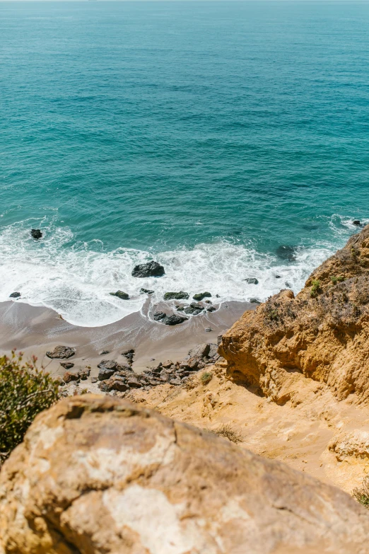 a man standing on top of a cliff next to the ocean, by Kristin Nelson, trending on unsplash, malibu canyon, slide show, high view, ocher and turquoise colors