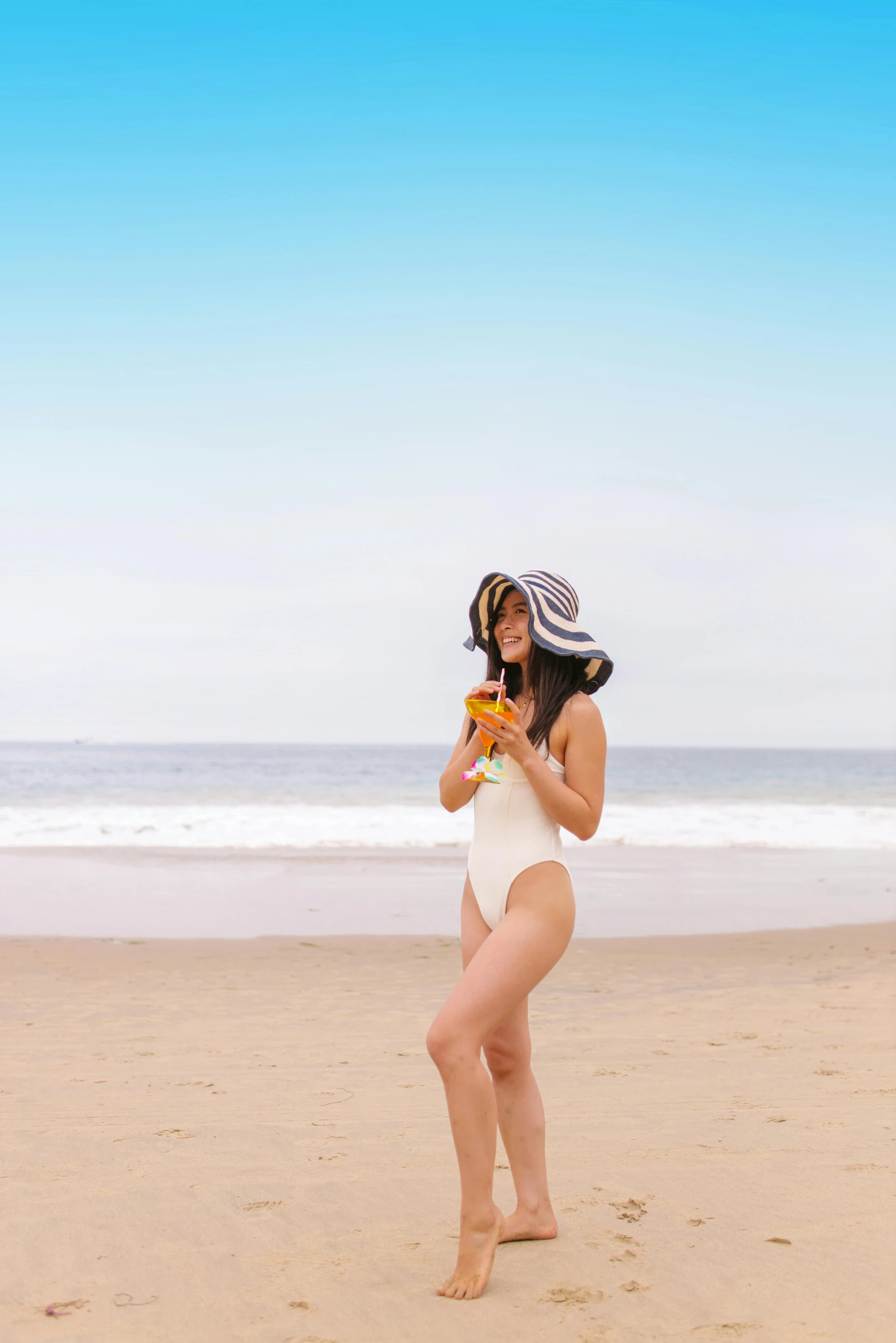 a woman standing on top of a sandy beach, inspired by Ren Hang, unsplash, wearing a white bathing cap, having a snack, ulzzang, monokini