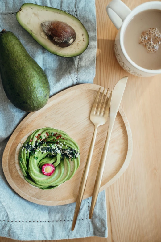 a wooden plate topped with avocado next to a cup of coffee, inspired by Sawa Sekkyō, renaissance, fork fork, biophilia mood, detailed product image, green and pink