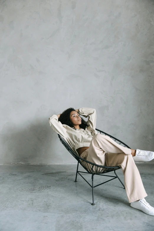 a woman sitting in a chair in a room, pexels contest winner, wearing off - white style, laid back features, african american young woman, very comfy]