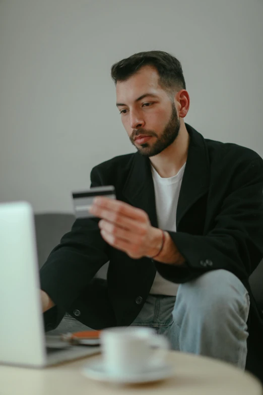 a man sitting on a couch holding a credit card, by Adam Rex, pexels contest winner, renaissance, wearing business casual dress, gif, trading, a young man