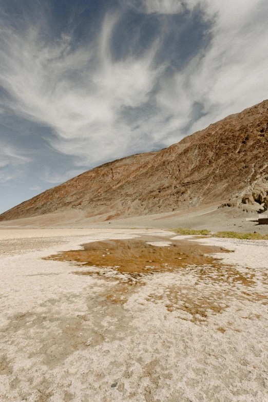 a man riding a skateboard on top of a sandy beach, a colorized photo, trending on unsplash, les nabis, dry river bed, death valley, white travertine terraces, 4k”