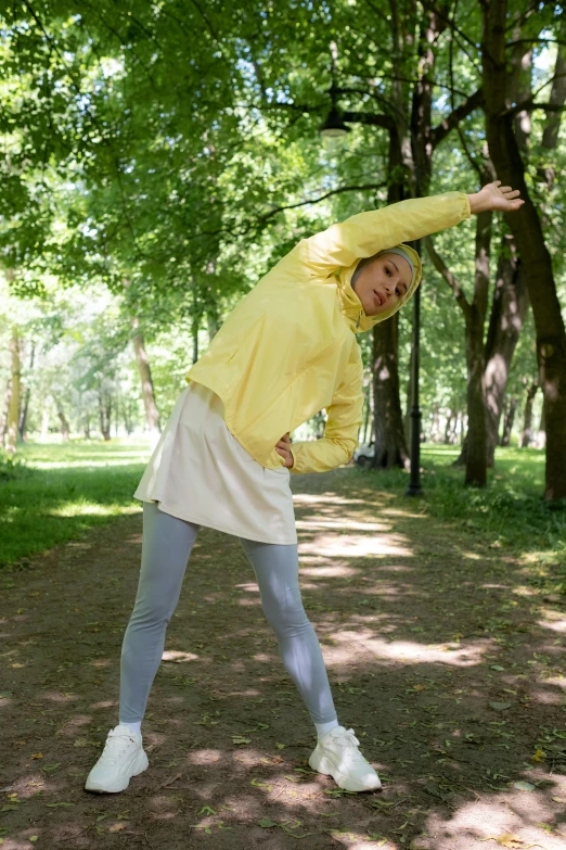 a woman throwing a frisbee in a park, by Grytė Pintukaitė, unsplash, renaissance, wearing a yellow hoodie, marjaryasana and bitilasana, gif, light yellow