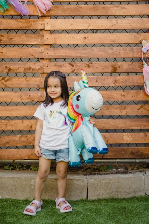 a little girl standing in front of a wooden fence, a cartoon, by Julia Pishtar, pexels contest winner, keanu reaves riding a unicorn, plush toy, party balloons, mai anh tran