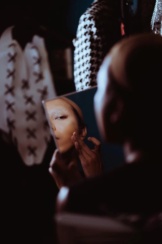 a woman that is standing in front of a mirror, a picture, inspired by Elsa Bleda, pexels contest winner, grace jones, fashion week backstage, pronounced facial contouring, face partially obscured