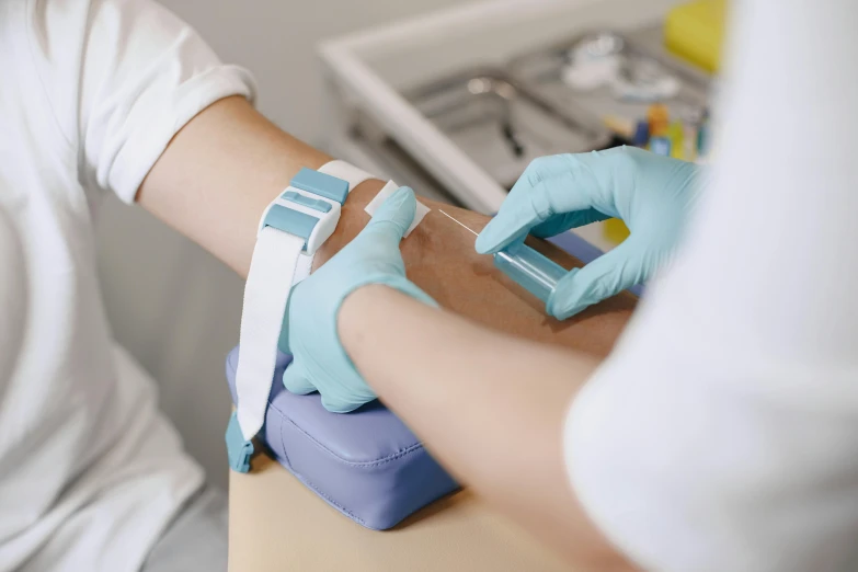 a person in a white shirt and blue gloves, a colorized photo, trending on pexels, surgical iv bag, bandage on arms, test, vials