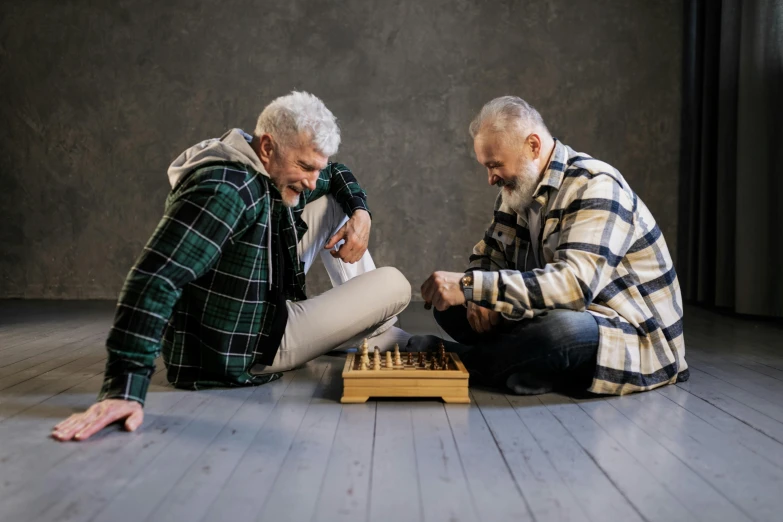 two men sitting on the floor playing chess, a portrait, pexels contest winner, silver hair and beard, on grey background, a wooden, thumbnail