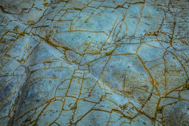 a close up of a rock with cracks in it, inspired by Filip Hodas, unsplash, concrete art, blue veins, tiled, ((rocks)), archival pigment print