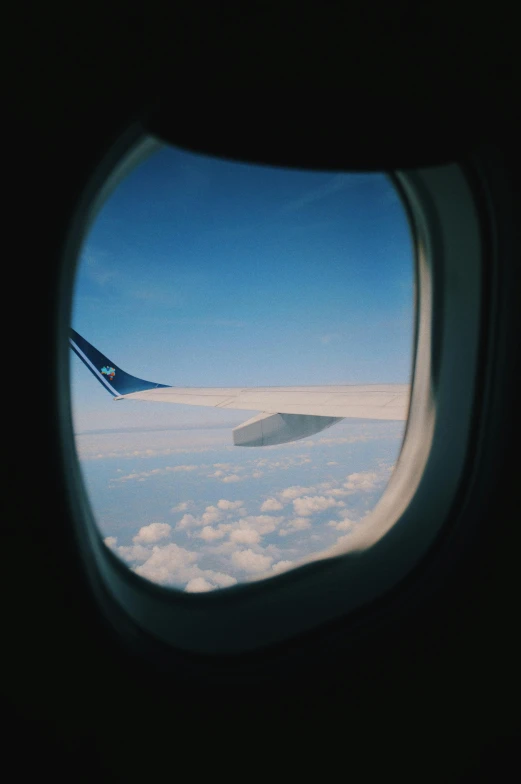 a view of the sky through an airplane window, by Jessie Algie, unsplash, taken on a 2000s camera, tail fin
