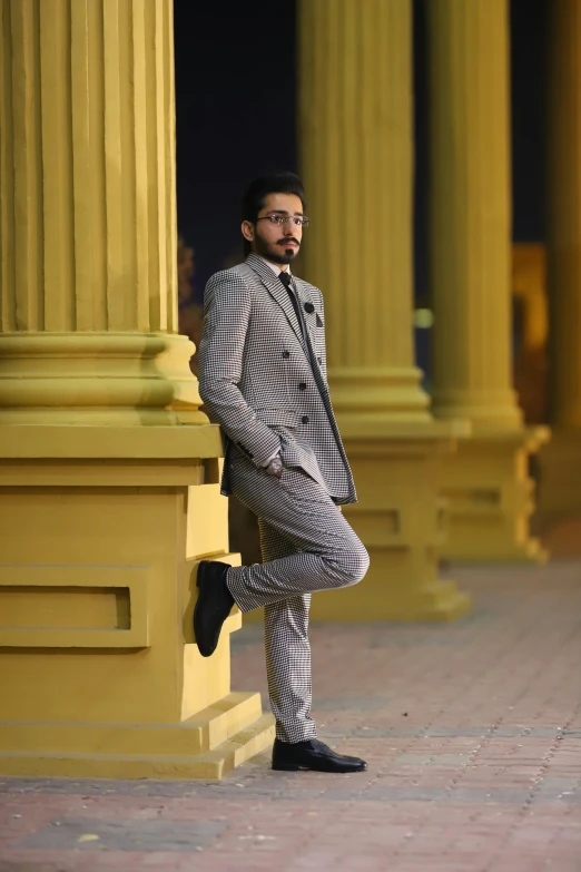 a man in a suit leaning against a column, an album cover, inspired by Ahmed Karahisari, pexels contest winner, full body pose, profile image, wearing fashion suit, snapchat photo