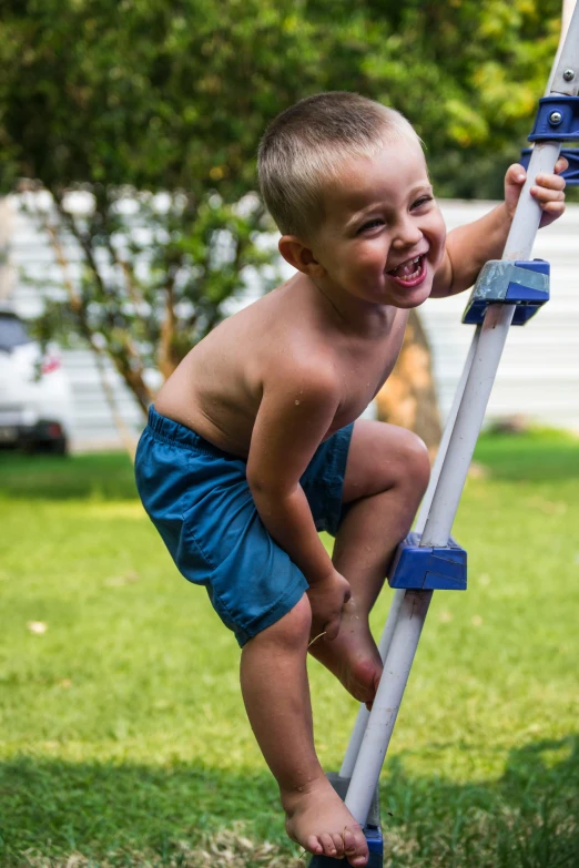 a little boy that is standing on a ladder, pexels contest winner, backyard wrestling, crutches, slip n slide, square