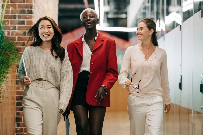 a group of three women walking down a hallway, trending on unsplash, diverse outfits, work clothes, happy friend, adut akech