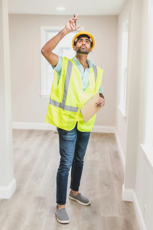 a man in a hard hat and safety vest holding a clipboard, a portrait, trending on pexels, renaissance, full body sarcastic pose, a portrait of rahul kohli, very tall ceilings, better homes and gardens