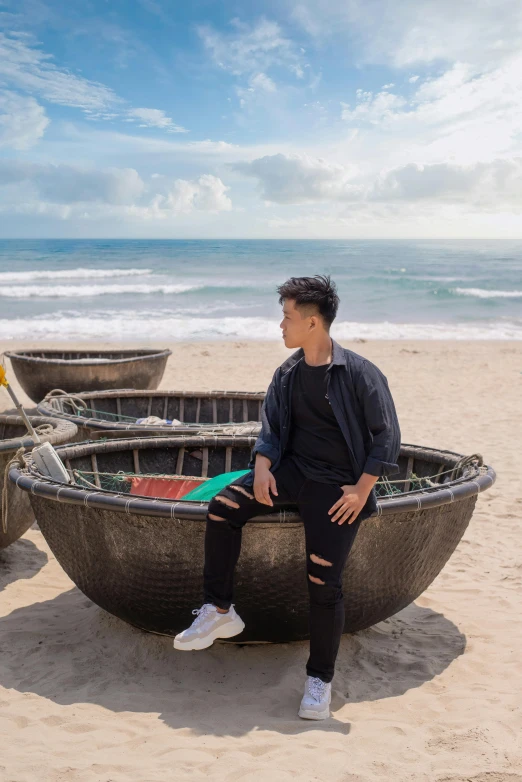 a man sitting in a boat on the beach, an album cover, inspired by Ruth Jên, trending on unsplash, happening, ao dai, teenage boy, sittin, bench