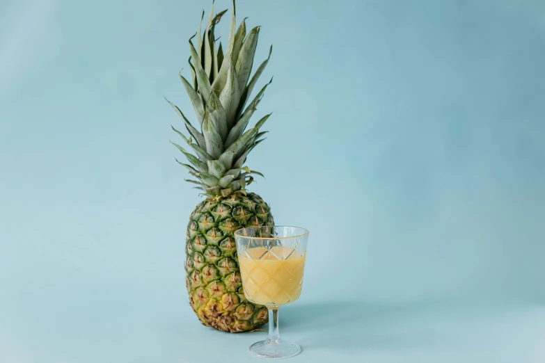 a pineapple next to a glass of orange juice, unsplash, 🦩🪐🐞👩🏻🦳, slush, studio shot, rum