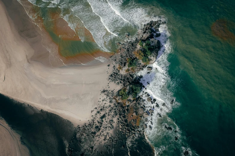 a large body of water next to a sandy beach, by Daniel Lieske, pexels contest winner, satellite imagery, jagged rocks, dark brown white green colours, flight