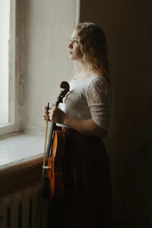 a woman standing in front of a window holding a violin, inspired by Anka Zhuravleva, pexels contest winner, renaissance, square, young blonde woman, concert, profile image